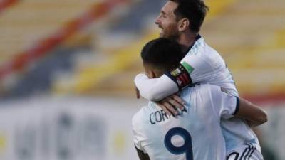 Argentina's Joaquin Correa celebrates with teammate Lionel Messi (top) after scoring against Bolivia during their 2022 FIFA World Cup South American qualifier football match at the Hernando Siles Stadium in La Paz on October 13, 2020, amid the COVID-19 novel coronavirus pandemic. (Photo by Juan KARITA / various sources / AFP)