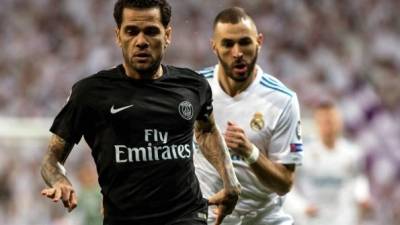 El defensa brasileño del Paris Saint Germain, Dani Alves, se escapa del francés Karim Benzema, del Real Madrid. Foto EFE