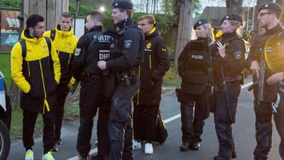 Los jugadores del Borussia Dortmund Nuri Sahin (i), Marcel Schmelzer (5i) y Sven Bender (2i) son escoltados luego de que el autobús del Borussia Dortmund fuera afectado por tres explosiones en Dortmund. FOTO EFE/STR