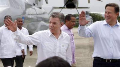 El presidente de Colombia, Juan Manuel Santos (i) y su colega de Panamá, Juan Carlos Varela (d) saludan en el poblado de Metetí. EFE.