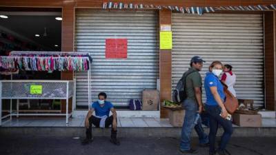 Transeúntes caminan en una calle de Managua. Pese a la aparente indiferencia del gobierno nicaragüense, algunos han tomado la iniciativa de protegerse.