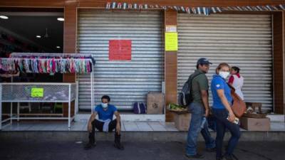 Transeúntes caminan en una calle de Managua. Pese a la aparente indiferencia del gobierno nicaragüense, algunos han tomado la iniciativa de protegerse.