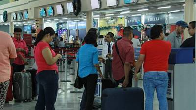 Viajeros mientras esperan para abordar su vuelo en el aeropuerto Villeda Morales. Foto: Cristina Santos.