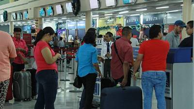 Viajeros mientras esperan para abordar su vuelo en el aeropuerto Villeda Morales. Foto: Cristina Santos.