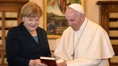 El papa Francisco intercambia regalos con la canciller alemana, Angela Merkel, durante una audiencia privada en el Vaticano. EFE