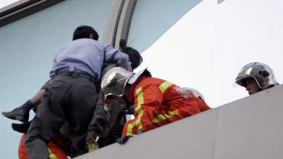 En la imagen, equipos de rescate impiden que un hombre salte para suicidarse. EFE/Archivo