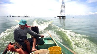 Joven conduce una lancha en el lago Maracaibo. Venezuela es uno de los más afectados.