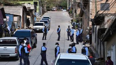 Police officers, along with the Army, assist Health personnel at the Abraham Lincoln colony in Tegucigalpa, on March 17, 2020 after two new cases of the new coronavirus, COVID-19 were confirmed. - The Honduran government decreed a curfew on Monday night 'to contain the advance of the coronavirus', confirming two new cases for a total of eight infected. (Photo by Orlando SIERRA / AFP)
