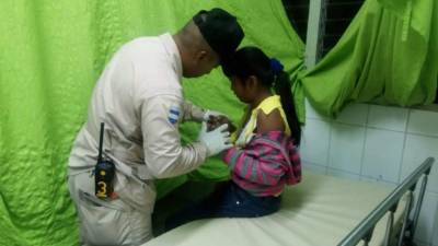 La niña Astrid Carolina Hernández Murillo es atendida por un bombero.