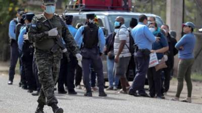 Autoridades mantenían detenidos el pasado miércoles por lo menos a una veintena de hondureños que entraron al país por una aduana terrestre, en un puesto de control en la comunidad de Villa Vieja, al oriente de Tegucigalpa (Honduras). EFE/Gustavo Amador