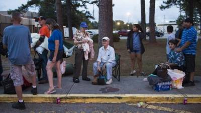 People line up to enter a hurricane shelter at Trask Middle School in wilmington, North Carolina, on September 11, 2018.Hurricane Florence would deliver a 'direct hit' to the US East Coast, emergency officials warned on September 11, 2018. More than one million people in North Carolina, South Carolina and Virginia have been told to flee their homes as the hurricane churns across the Atlantic Ocean towards the coast. / AFP PHOTO / Andrew CABALLERO-REYNOLDS