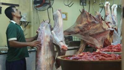 Un vendedor pesa una pieza de res en un puesto del mercado Medina. Foto: Amilcar Izaguirre.