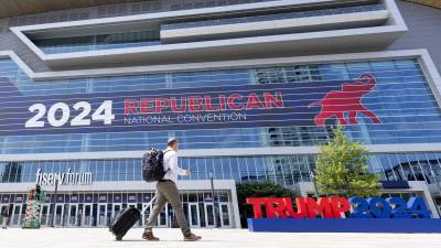 Una persona pasa junto a un gran letrero de la Convención Nacional Republicana en el Foro Fiserv en Milwaukee, Wisconsin, EEUU.