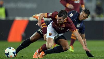 Kevin Strootman de la Roma recibe una falta del colombiano del Inter, Fredy Guarín.