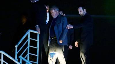 Brazilian ex-president (2003-2011) Luiz Inacio Lula da Silva arrives at the Federal Police headquarters where he is due to serve his 12-year prison sentence, in Curitiba, Parana State, Brazil, on April 7, 2018.Brazil's election frontrunner and controversial leftist icon said Saturday that he will comply with an arrest warrant to start a 12-year sentence for corruption. 'I will comply with their warrant,' he told a crowd of supporters. / AFP PHOTO / Heuler Andrey