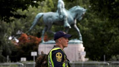 Un policía patrulla en el parque donde se erige la estatua ecuestre del general confederado Robert E. Lee, cuyo proyecto de remoción provocó los disturbios de hace un año.