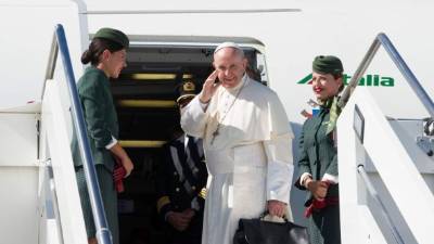 In this handout photograph released by The Osservatore Romano, Pope Francis (C) waves as he boards an aircraft at Fiumicino International Airport in Rome on September 6, 2017, as he prepares to travel to Colombia.Pope Francis is starting his fifth visit as pontiff to his native Latin America region with a trip to Colombia as it moves on from a half-century civil conflict. / AFP PHOTO / OSSERVATORE ROMANO / HO / RESTRICTED TO EDITORIAL USE - MANDATORY CREDIT 'AFP PHOTO / OSSERVATORE ROMANO' - NO MARKETING NO ADVERTISING CAMPAIGNS - DISTRIBUTED AS A SERVICE TO CLIENTS