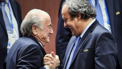 Michel Platini saluda muy sonriente a Joseph Blatter. Foto AFP