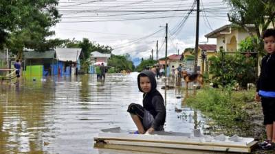 Children are seen at a flooded street at the Palermo neighborhood in El Progreso, Yoro department, Honduras on November 5, 2020, after the passage of hurricane Eta. (Photo by - / AFP)