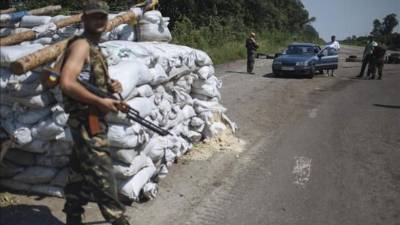 Varios soldados ucranianos comprueban este viernes un coche en el punto de vigilancia del pueblo del este de Ucrania de Nikishino, a 20 kilómetros del pueblo Grabovo, cerca del lugar en el que se encuentro los restos del vuelo MH17 de Aerolíneas Malasia, en Ucrania. EFE