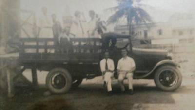 Dos hombres descansan en uno de los primeros vehículos que llegaron a San Pedro Sula.