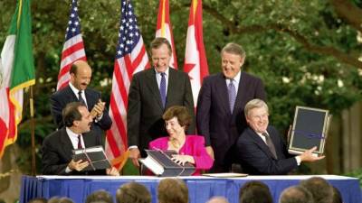 Los presidentes de México, Carlos Salinas de Gortari, EE.UU., George Bush, y el primer ministro de Canadá, Brian Mulroney, firman el Nafta en 1992.
