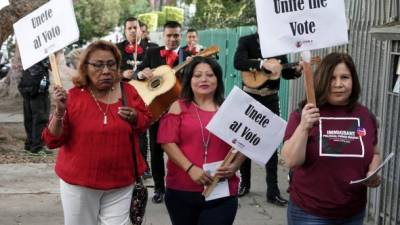 MAN01. LOS ÁNGELES (ESTADOS UNIDOS), 06/11/2018.- Votantes de origen latino portan carteles en los que puede leerse ''Únete al voto'', mientras se dirigen a votar seguidas de una banda de mariachis, en Los Ángeles, California (Estados Unidos), hoy, 6 de noviembre de 2018. Estados Unidos celebra hoy unas elecciones legislativas en las que se renovarán los 435 escaños de la Cámara de Representantes y un tercio de los 100 del Senado, y servirán para medir el grado de apoyo del presidente, Donald Trump, tras dos años de mandato. EFE/ Mike Nelson