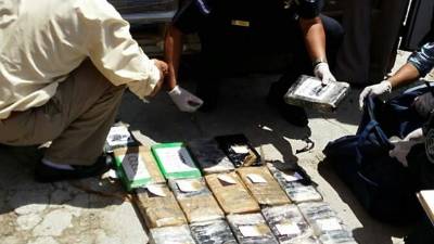 Las autoridades proceden al conteo de los kilos de cocaína incautados.