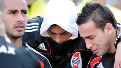 River Plate' players Gonzalo Piris, left, Carlos Arana, center, and Facundo Affranchino react after an Argentine promotion soccer game with Belgrano in Buenos Aires, Argentina, Sunday June 26, 2011. Legendary club River Plate has been relegated to the Argentine second division for the first time in its 110-year history, going down Sunday after a 1-1 draw with Belgrano in the second leg of a demotion playoff. (AP Photo/Eduardo Di Baia)