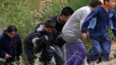 Fotografía de archivo de menores cruzando la frontera entre México y Estados Unidos.