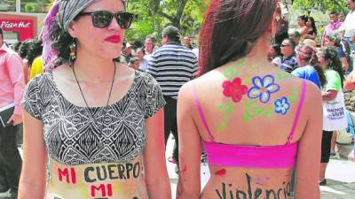 Dos mujeres en el parque central con mensajes de igualdad y alto a la violencia en el cuerpo. Foto: Cristina Santos.