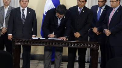 El presidente Juan Orlando Hernández en la firma del decreto la tarde de ayer en Presidencial junto a miembros del Congreso Nacional y operadores de justicia.