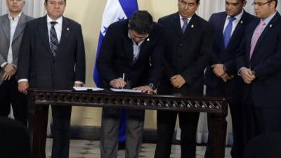 El presidente Juan Orlando Hernández en la firma del decreto la tarde de ayer en Presidencial junto a miembros del Congreso Nacional y operadores de justicia.
