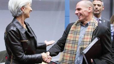 Yanis Varoufakis, ministro griego de Finanzas, luciendo una bufanda Burberry, saluda a Christine Lagarde, la directora gerente del Fondo Monetario Internacional.