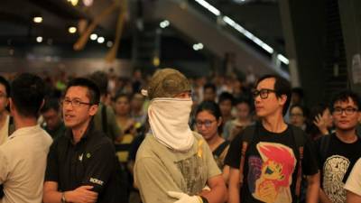 Manifestantes a favor de la democracia permanecen de pie en la zona ocupada por ellos en la estación de tren de Admiralty en Hong Kong.