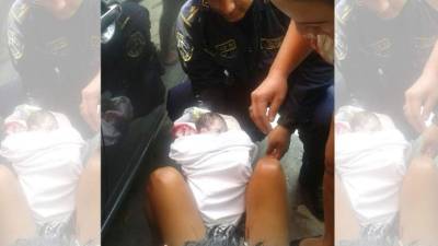 El Policía asistiendo el nacimiento en la acera.