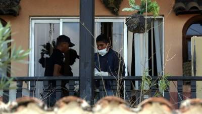 Agentes de inspecciones oculares realizaron una revisión de la casa para encontrar pistas que los lleven a los asesinos.