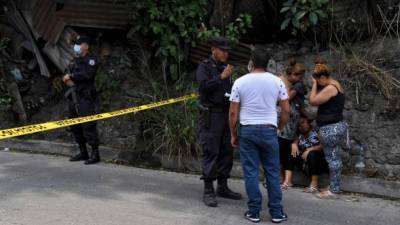 Familiares de un hombre asesinado por supuestos pandilleros lloran en la escena del crimen en El Salvador./AFP.
