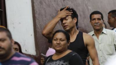 A man wipes his forehead as he waits in line with other voters at a polling station during the presidential election in Caracas, Venezuela, Sunday, Oct. 7, 2012. President Hugo Chavez is running against opposition candidate Henrique Capriles. (AP Photo/Ariana Cubillos)