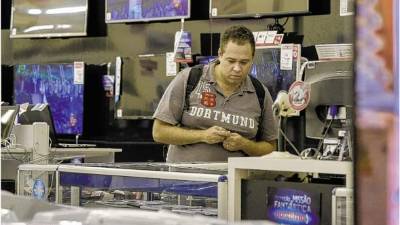 Un consumidor revisa productos en una tienda de electrónicos en São Paulo. Los costos de financiamiento han subido en Brasil.