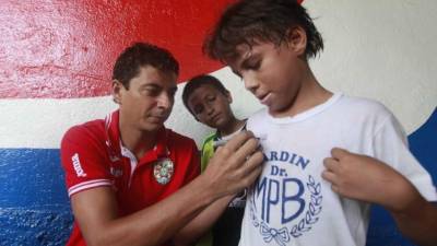 El verdolaga Mauricio Sabillón firma la camisa de un pequeño de la Escuela Paz Barahona.
