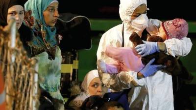 Un niño es llevado en brazo por un rescatista tras llegar al puerto italiano de Pozzallo hace unos días.