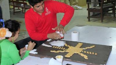 Los jóvenes de la comunidad de Cristo Salvador elaboran uno de los murales del viacrucis. Fotos: Cristina Santos