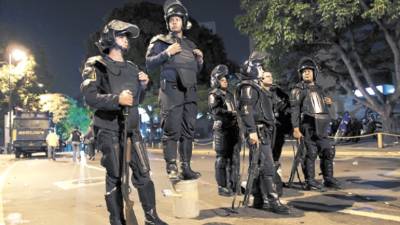 Riot police officers stand on guard during a march in Caracas, Wednesday, May 27, 2009. Venezuela's President Hugo Chavez's opponents marched to support press freedom after two years of his government refused to renew the concession of an opposition television station also in support of Globovision the only remaining anti-Chavez channel on the open airwaves that is currently under investigation by broadcast regulators. (AP Photo/Ariana Cubillos)
