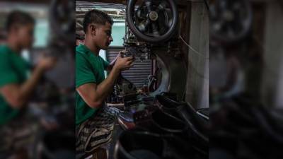 Un joven confecciona calzado en un taller ubicado en el barrio Guamilito de San Pedro Sula. Foto: Yoseph Amaya
