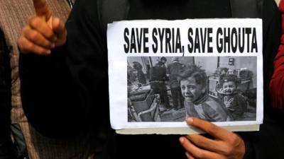 Un miembro del Foro Global de Investigación del Islam sostiene una pancarta en la que aparecen unos niños sirios en los bombardeos de la última semana en Guta Oriental, durante una protesta contra la muerte de civiles en el conflicto, en Srinagar, la capital estival de la Cachemira india (India), hoy 27 de febrero de 2018. EFE/ Farooq Khan