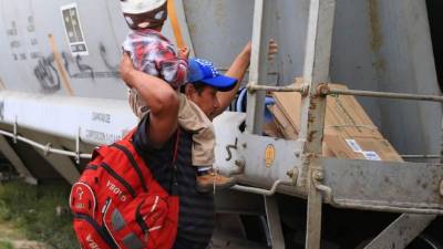 Una padre y su hijo hondureño cruzando en La Bestia en México. Foto: LA PRENSA