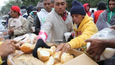 AME4970. CIUDAD DE MÉXICO (MÉXICO), 14/11/2018.- Grupos de personas de la segunda caravana migrante reciben comida hoy, jueves 15 de noviembre de 2018, en el deportivo Jesús Martínez 'Palillo', en Ciudad de México (México). El invierno llegó hoy repentinamente a Ciudad de México, donde la incesante lluvia y las bajas temperaturas están afectando directamente a las personas de la segunda caravana migrante, que se encuentra acampada en un complejo deportivo de la capital. EFE/Mario Guzmán