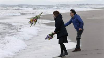 Varios familiares de las víctimas arrojaron al mar ofrendas florales, durante la conmemoración del quinto aniversario del impacto del tsunami en la isla.