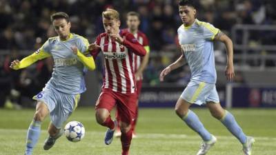 El delantero francés del Atlético de Madrid, Antoine Griezmann lucha por el balón con Nemanja Maksimovic.